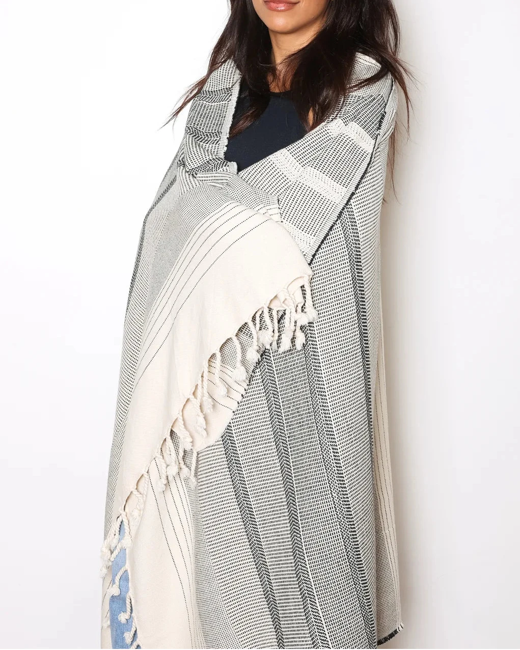 Model wrapped in The Sonnet striped Turkish cotton throw by Tofino Towel Co. in cream and grey with hand tied tassels. 